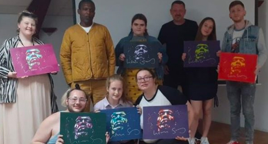 An image of a group of young people displaying their paintings