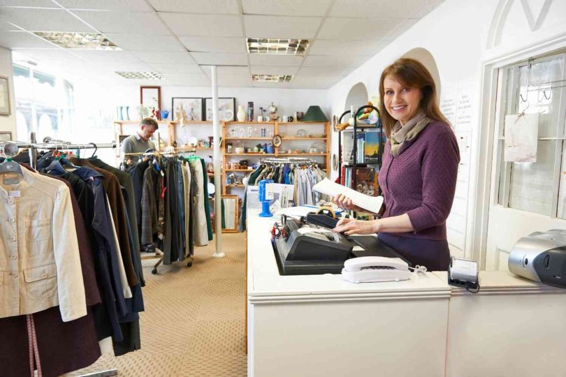 Woman stood behind the till in a charity shop